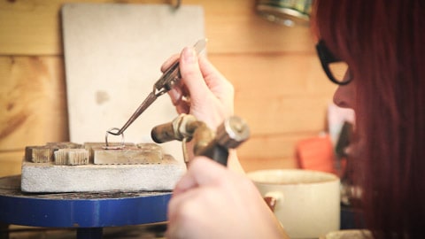A jeweler uses heat to join metal.