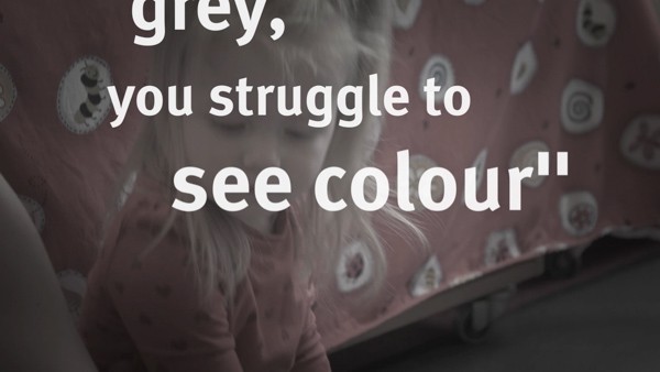 Shows text "you struggle to see in colour" over a young girl playing/