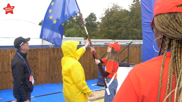 Action for Children volunteer is shown how to handle the flag and flag pole for the opening ceremony.