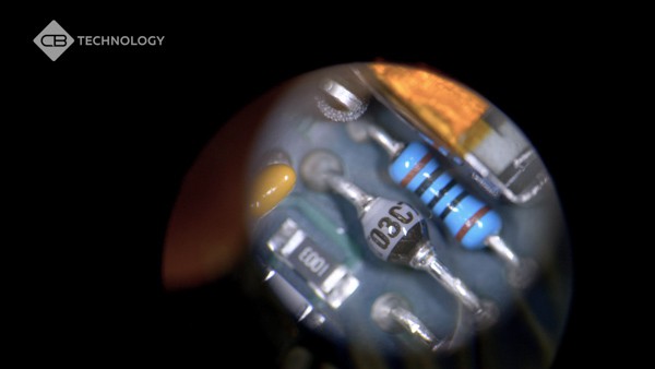Looking through a microscope at a printed circuit board.
