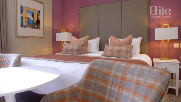 A bed with cushions and a table and chairs.