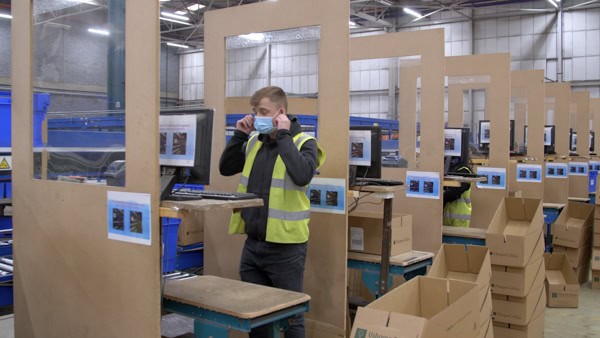 Man takes of his mask when at his workstation.