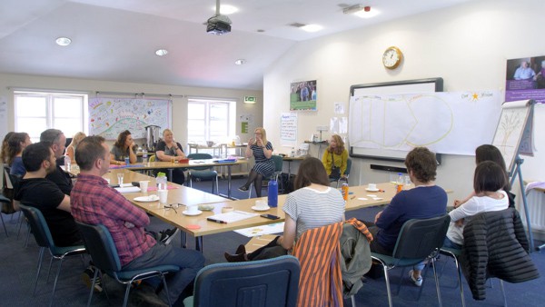 A room of people learns about drawing for better communication.