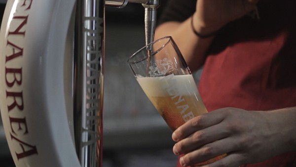 A pint of lager is seen being poured from a tap.