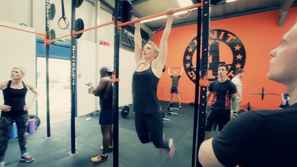 Woman does pull-ups while working out.