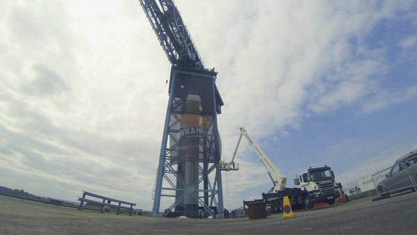 A massive banner is being added to a huge crane.